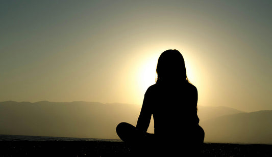 Woman sitting watching the sunset, symbolizing personal transformation and mindfulness inspired by Joe Dispenza courses on MyPremiumCourses